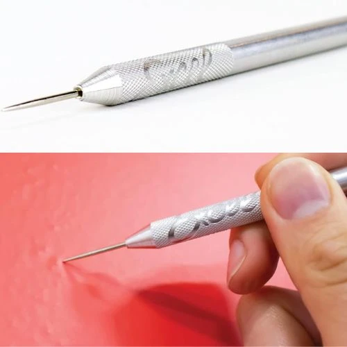 Two close-up views of the Excel Blades Scratch Awl with a .060 inch stainless steel tip and a textured aluminum handle, showing it held by a hand punching a red material.